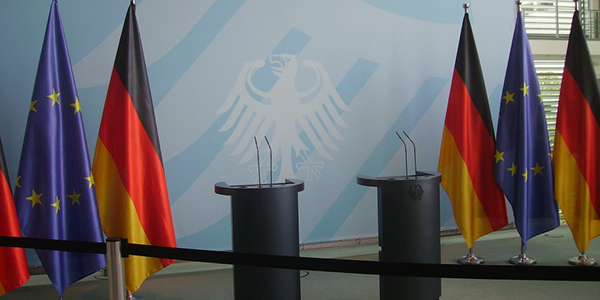 Deutsche und europäische Fahnen neben Rednerpult